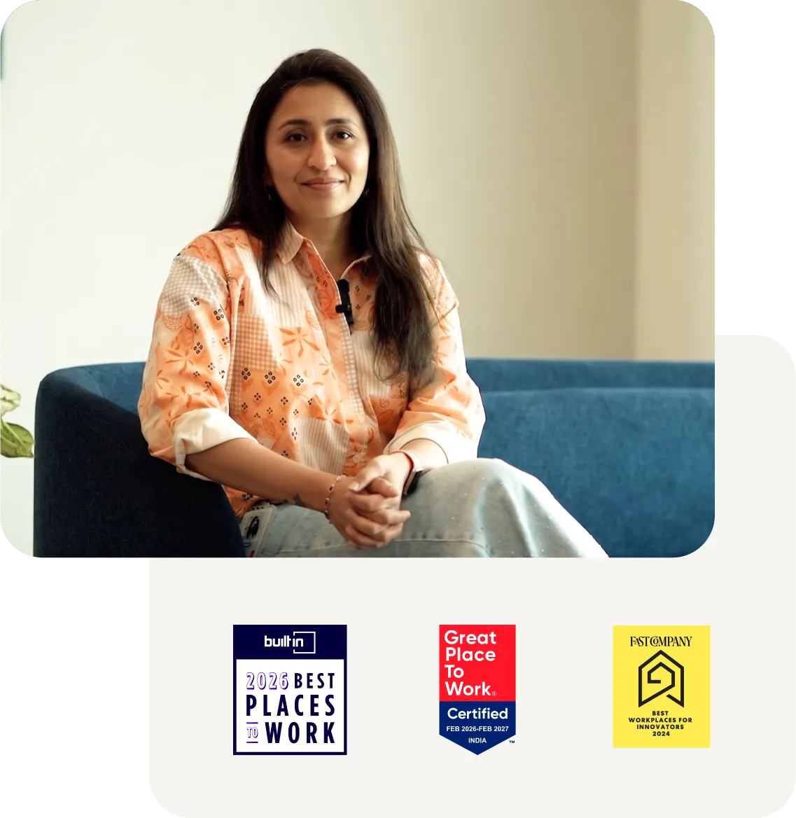 A professional sitting on a couch, with awards for best places to work displayed below.