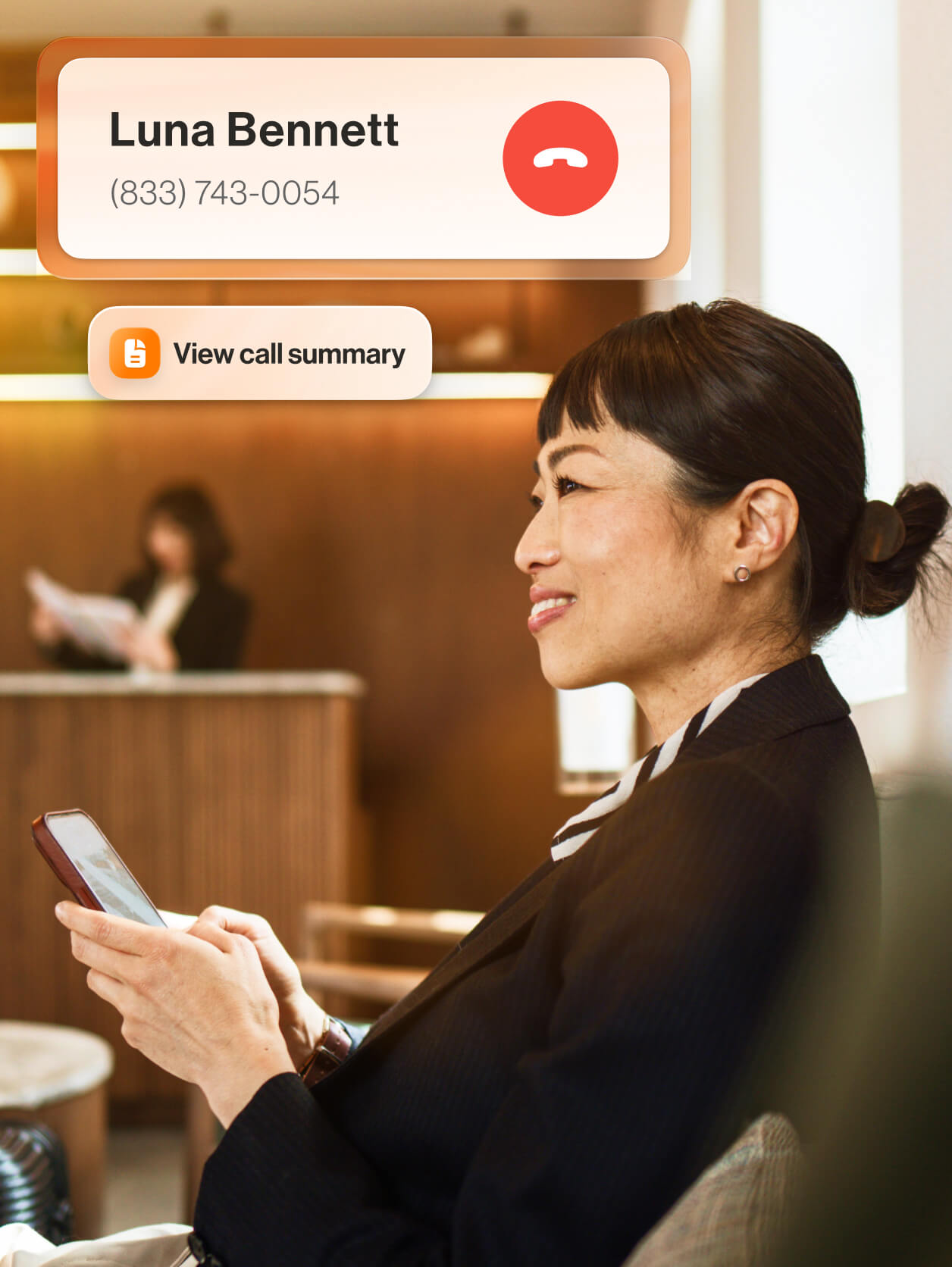 A smiling woman holding her mobile phone with an ongoing call