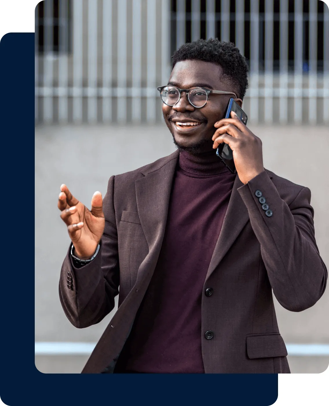 A man wearing a suit talks to someone on his mobile phone