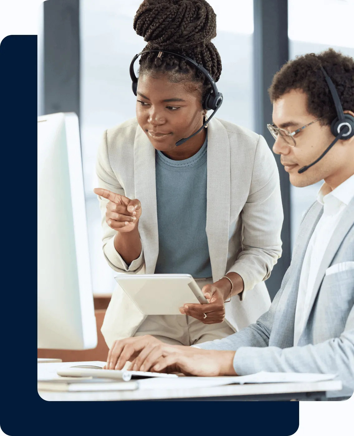 A supervisor guides an agent on a call while pointing to the computer screen