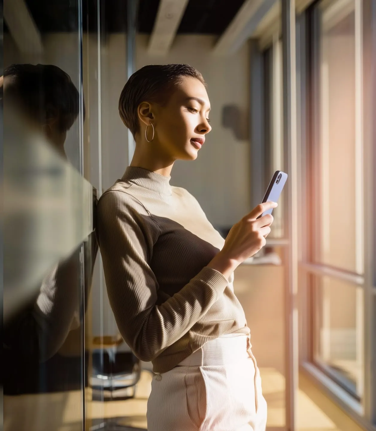 A young woman is reading messages on her mobile phone.