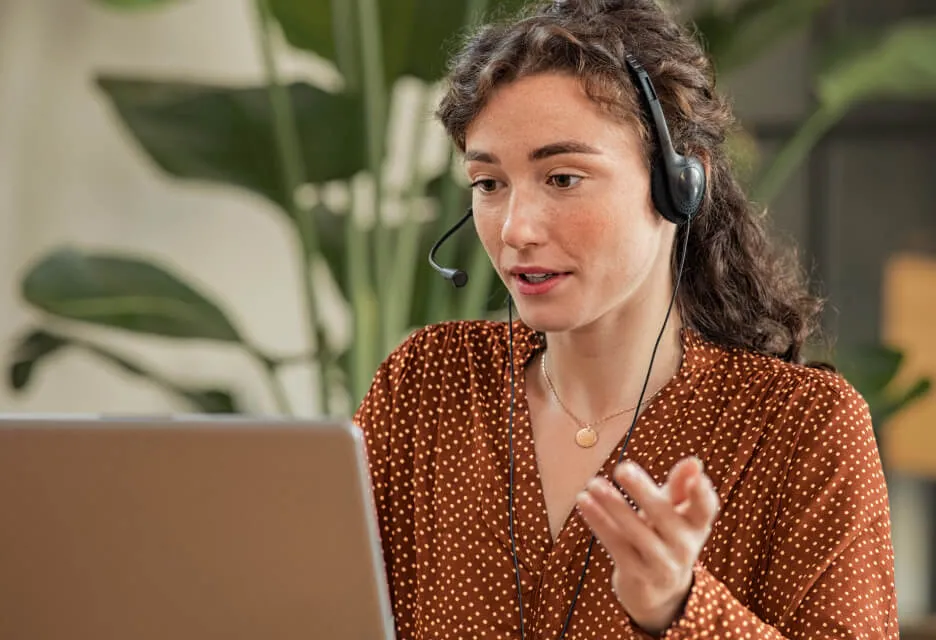 A female agent on a call in front of her laptop