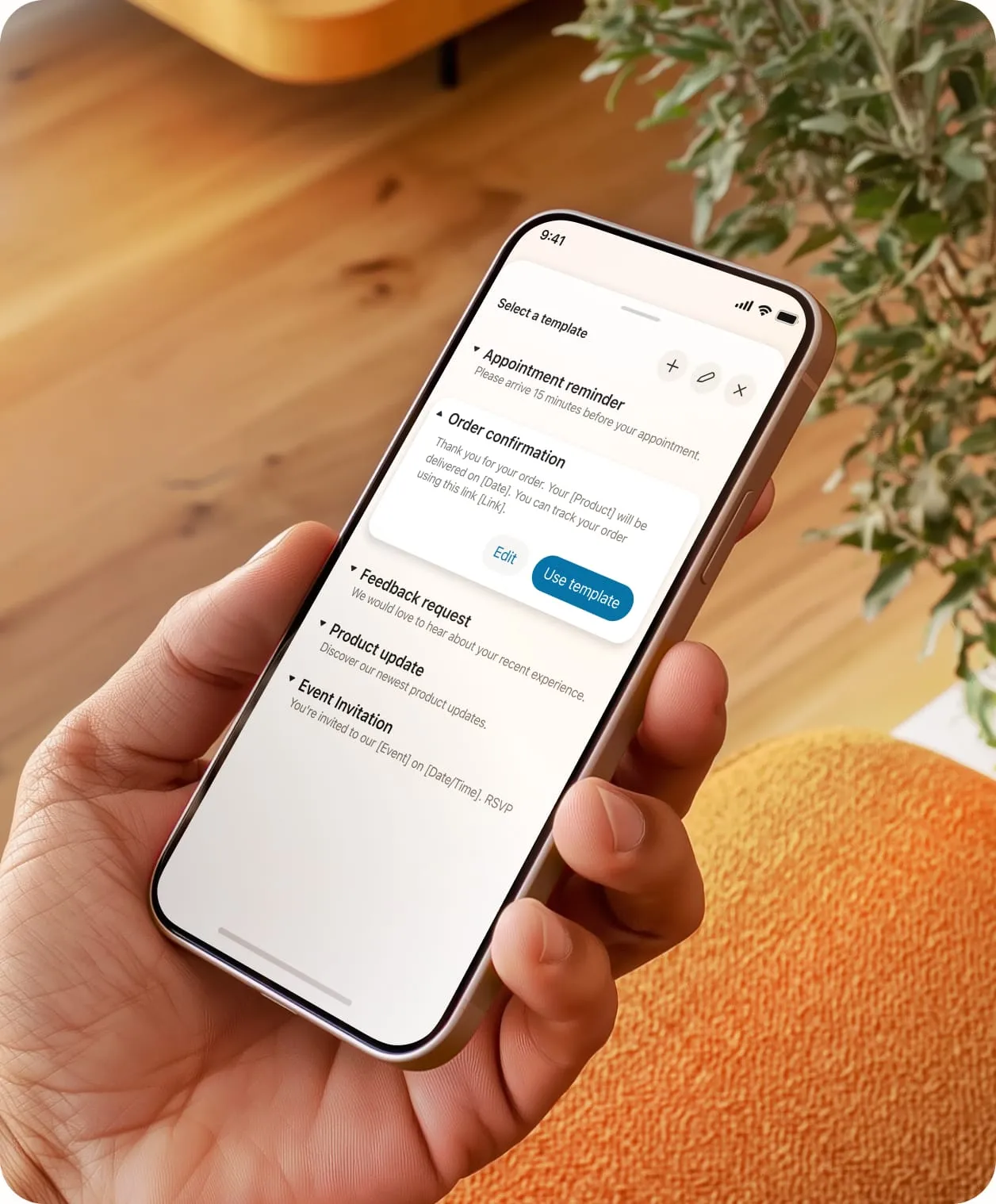The enhanced business SMS choose a template feature on a mobile phone held in hand