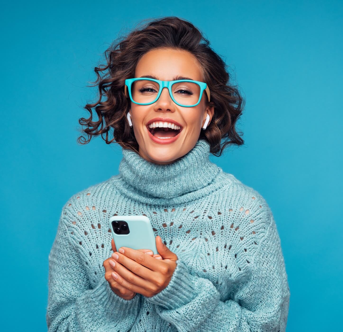 woman standing in front of blue background with smart phone